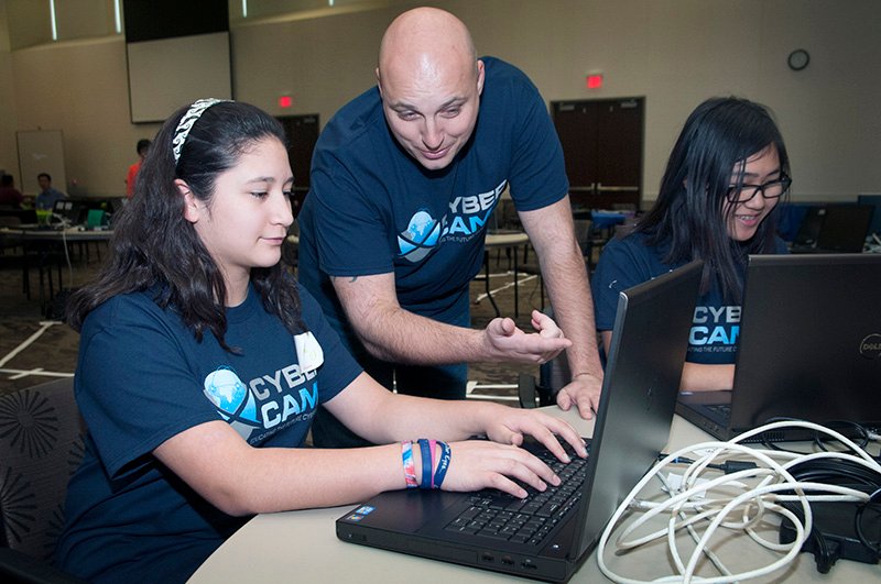 Students and professors work at the cyber security camp.