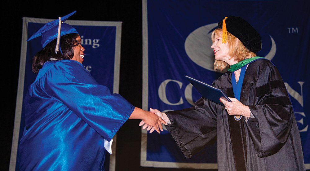 Dr. Sherry Schumann congratulates Collin College graduate at Commencement event.