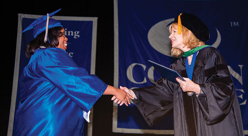 Dr. Sherry Schumann congratulates Collin College graduate at Commencement event.